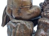 a bronze statue of a man and a dog on a rock