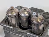 three silver containers sitting in a metal container
