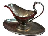 a silver gravy on a silver plate on a white background