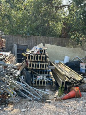 un tas de vieilleries dans un jardin, près d'une clôture