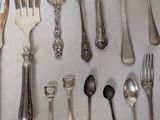 a lot of silver spoons and forks on the table