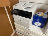 une imprimante blanche posée sur un meuble blanc