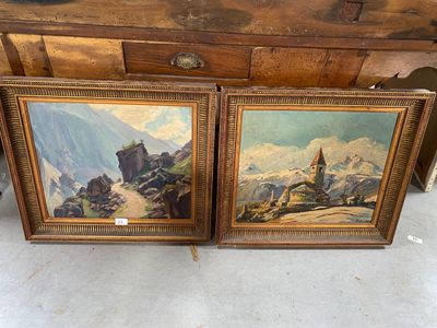 Deux tableaux représentant un paysage de montagne sont exposés devant une commode.