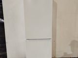 a white refrigerator sitting on a pallet in a warehouse