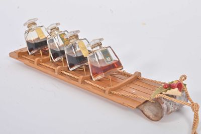une luge en bois sur laquelle sont posées six bouteilles d'alcool