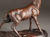 bronze statue of a stag on a base on a gray background