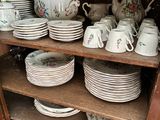 a wooden cabinet with many plates and cups on it