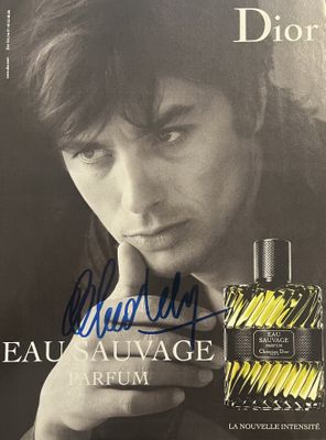 une image d'un magazine sur laquelle figure la photo d'un homme tenant un flacon de parfum