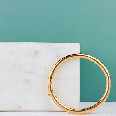 un bloc de marbre blanc surmonté d'un anneau doré