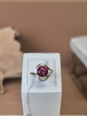 a pink ring sitting in a white box on a table