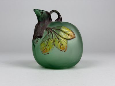 Petite vase en verre teinté vert en forme de cucurbitacée.