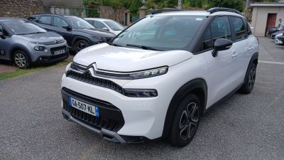 La Citroën blanche est garée sur un parking, à côté d'autres voitures