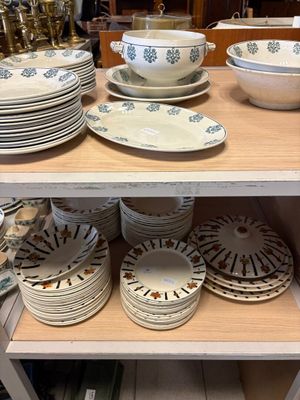 de nombreuses assiettes et bols sur une étagère dans un magasin
