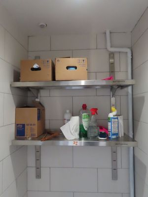 a metal shelf with boxes and cleaning products on it