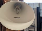 a large white speaker on a stand in a room