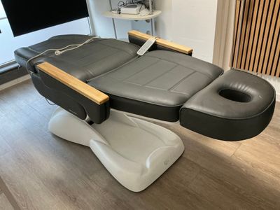 un gros plan d'un fauteuil de massage noir et blanc posé sur un parquet