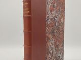 un vieux livre à la couverture marron et à la reliure en cuir marron