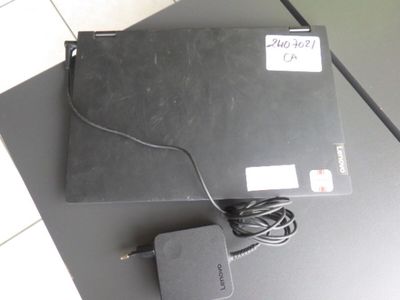un ordinateur portable posé sur une table, avec un chargeur dessus