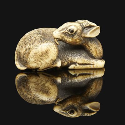 a small elephant figurine sitting on a black surface