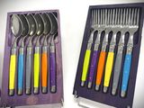 six forks and six spoons in a purple box