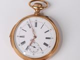 a gold pocket watch with roman numerals on it