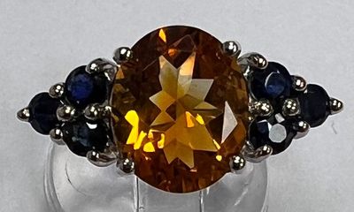 une bague ornée d'une grosse citrine entourée de saphirs bleus
