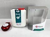 un objet rouge et blanc posé à côté d'une boîte blanche