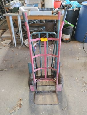 a pink hand truck that is sitting in a garage