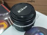 a camera lens sitting on top of a box next to a dvd