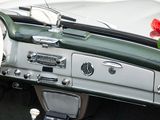dashboard of a green and white car with a red rose in the background