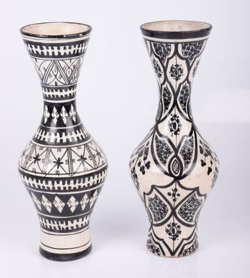 une paire de vases noir et blanc ornés de motifs sur fond blanc