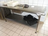 une table en métal sur laquelle est posé un panier, dans une cuisine