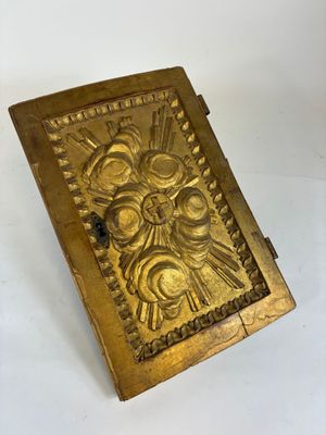 boîte plaquée or sur laquelle est représenté le visage d'un homme