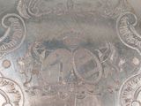 a silver plate with a design on it on a table