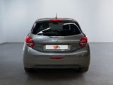 the rear end of a silver car in a room with a white wall