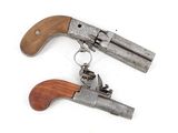 two old revolvers that are on a white surface
