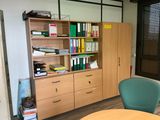 a desk with a chair and bookshelf in a room