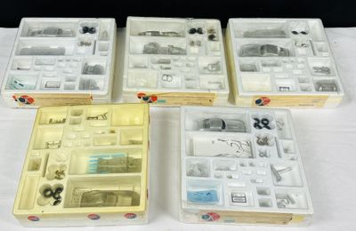 Quatre boîtes contenant des objets divers sont posées sur une table.