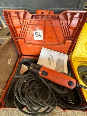 une boîte à outils contenant des outils, posée sur le sol