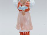 a figurine of a woman in a pink dress and red boots