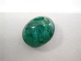 a close up of a green stone on a white surface