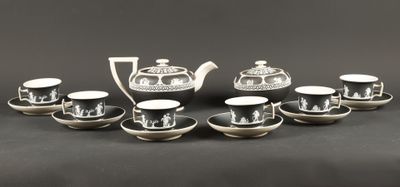 un ensemble de tasses et soucoupes noires et blanches posées sur une table