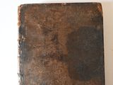 an old book sitting on a table with a white background