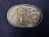 an image of a bronze belt buckle with a horse and rider on it