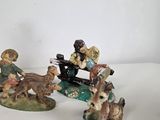 three figurines of people riding on a horse drawn carriage