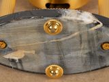 a clock that is on a table with a gold base