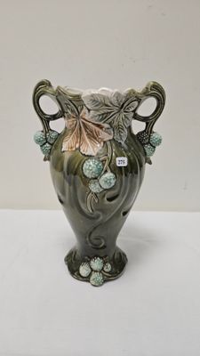 un vase vert avec des fleurs posé sur une table