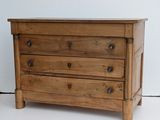 a small wooden chest of drawers on a white floor