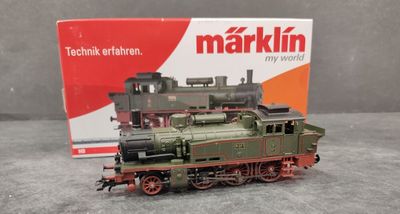 un petit train posé sur une table à côté d'une boîte