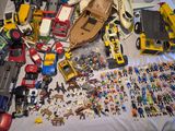 a lot of toys on a bed with a white sheet